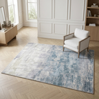 Modern living room with a blue patterned rug, white armchair, and wooden furniture.