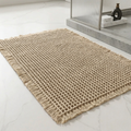 Beige woven rug on a light gray floor with a modern decor background.