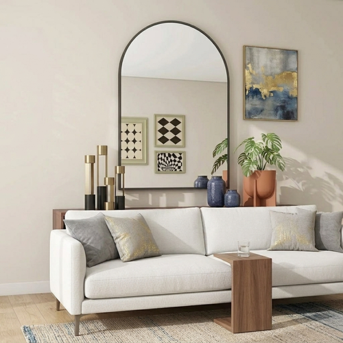Modern living room with a white sofa, decorative pillows, a wooden side table, and wall art.