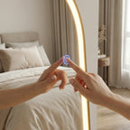 Person interacting with a smart mirror in a bedroom setting