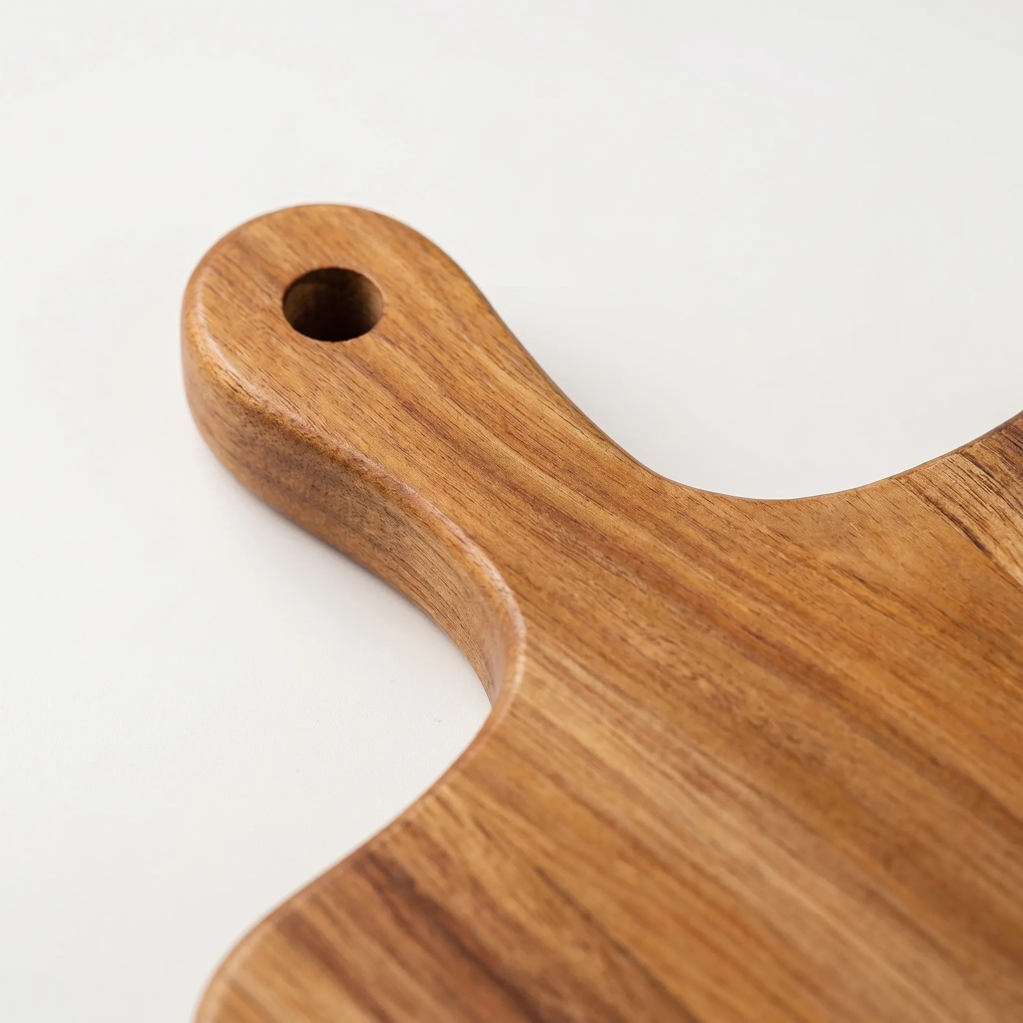 Wooden cutting board with handle on a white background