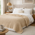 Soft cotton blanket in a beige color on a big bed. 