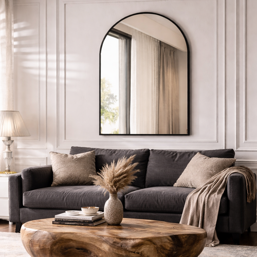 Living room with a gray sofa, wooden coffee table, and decorative mirror.