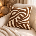 Decorative pillow with brown and beige pattern on a beige sofa