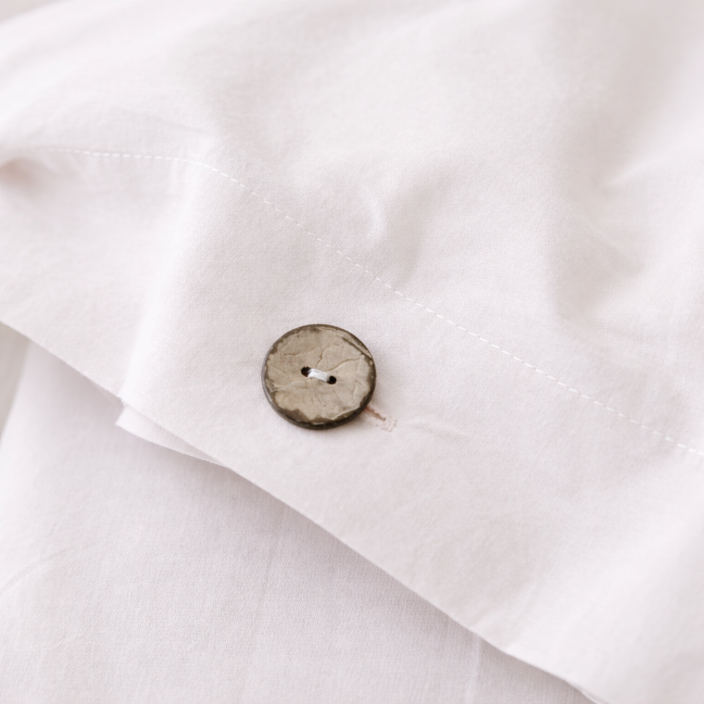 Close-up of a wooden button on a white fabric background
