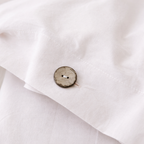 Close-up of a wooden button on a white fabric background
