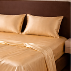 Gold satin bedding on a bed in a bedroom setting