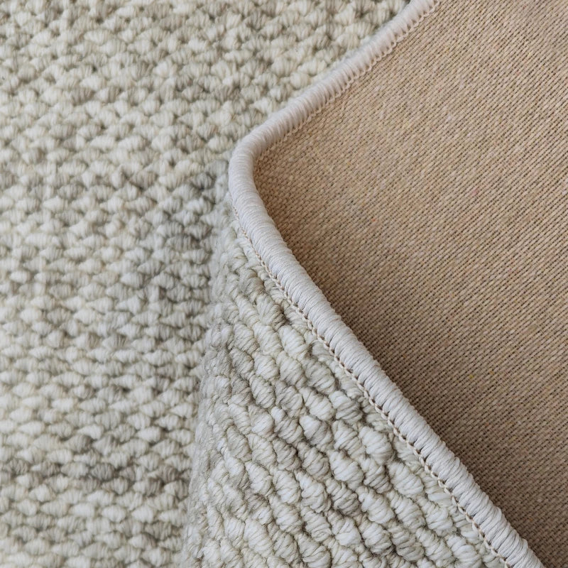 Close-up of beige and brown textured carpet corner