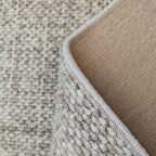 Close-up of beige and brown textured carpet corner