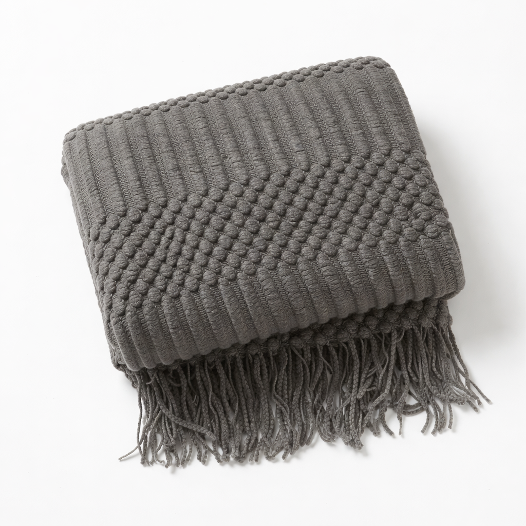Gray blanket throw on a white studio.