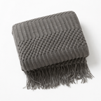 Gray blanket throw on a white studio.