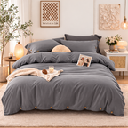 Gray bedding set on a bed in a bedroom with decorative elements.
