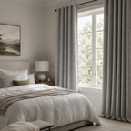 Cozy bedroom with a bed, lamp, and large window with curtains in a nice soft gray.