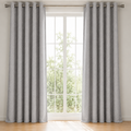 Gray curtains with grommets on a window with a view of greenery outside.