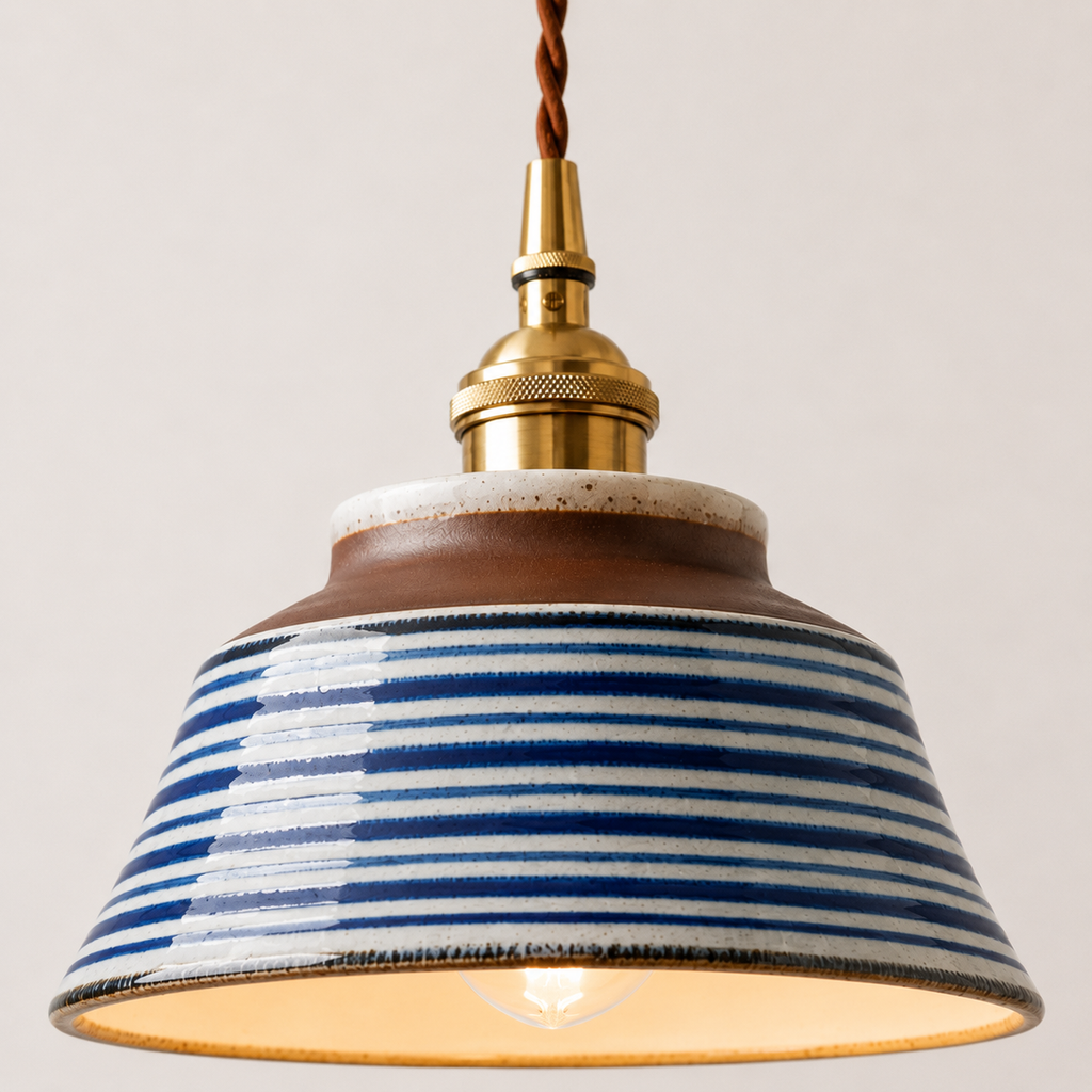 Pendant light with striped shade and brass fitting on a plain background