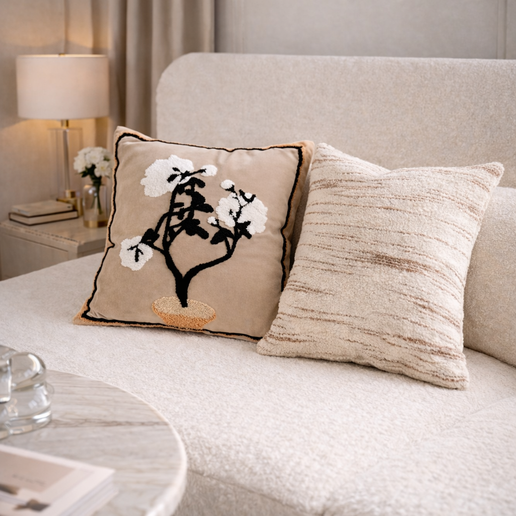 Decorative pillow with floral design on a beige sofa in a living room setting.