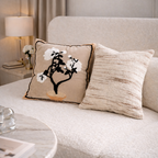 Decorative pillow with floral design on a beige sofa in a living room setting.