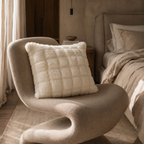 Chair with plush fussy faux fur pillow in white in it. 
