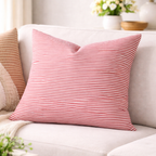 Pink striped pillow on a white sofa with a blurred background