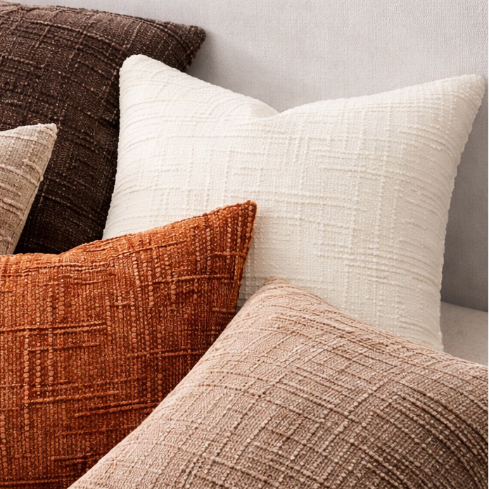 Collection of textured pillows in various colors on a sofa.