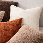 Collection of textured pillows in various colors on a sofa.