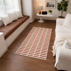 Living room with a patterned rug, brown bench, and white sofa.