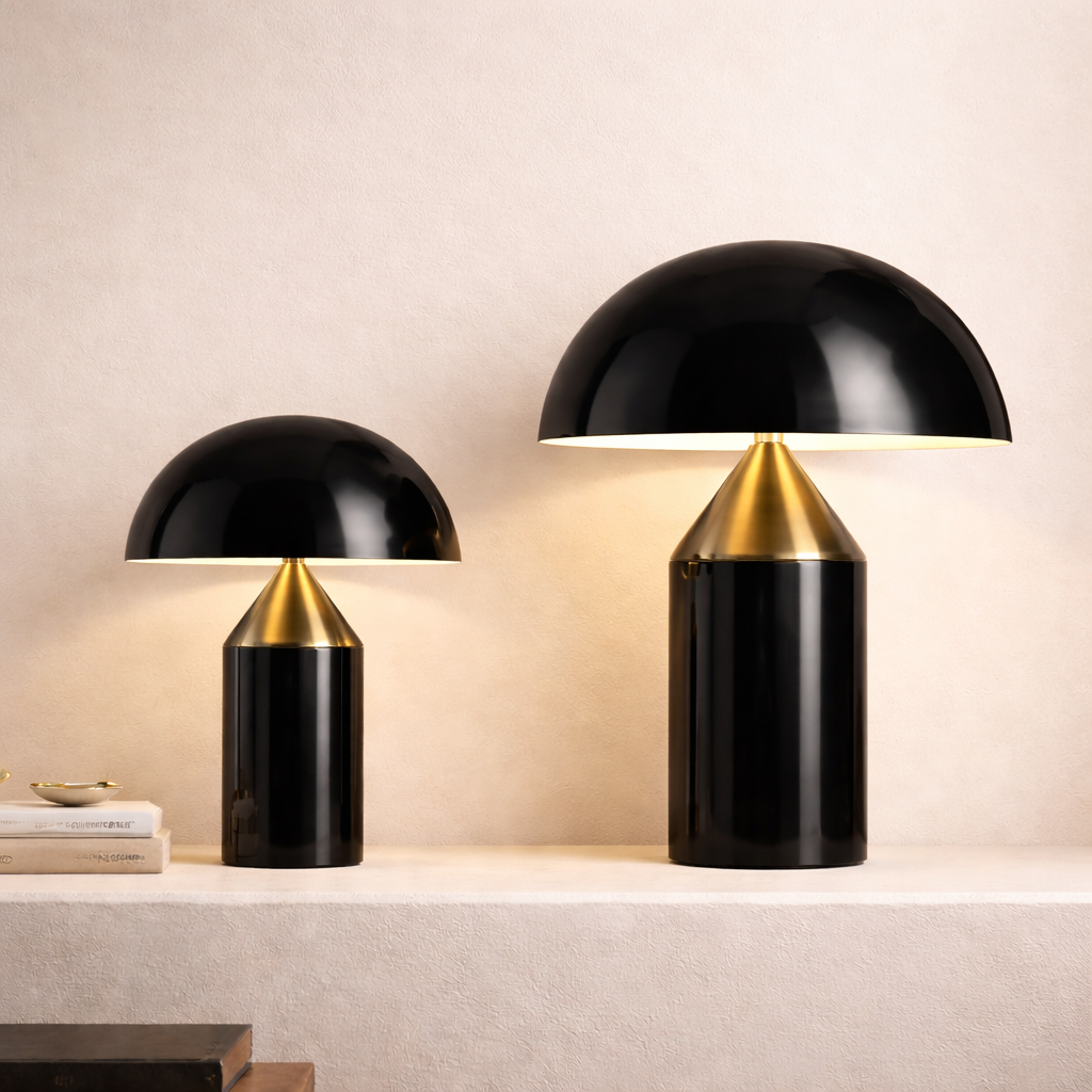 Two black table lamps with gold bases on a light-colored surface.