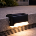 Black solar-powered outdoor light fixture on a concrete surface
