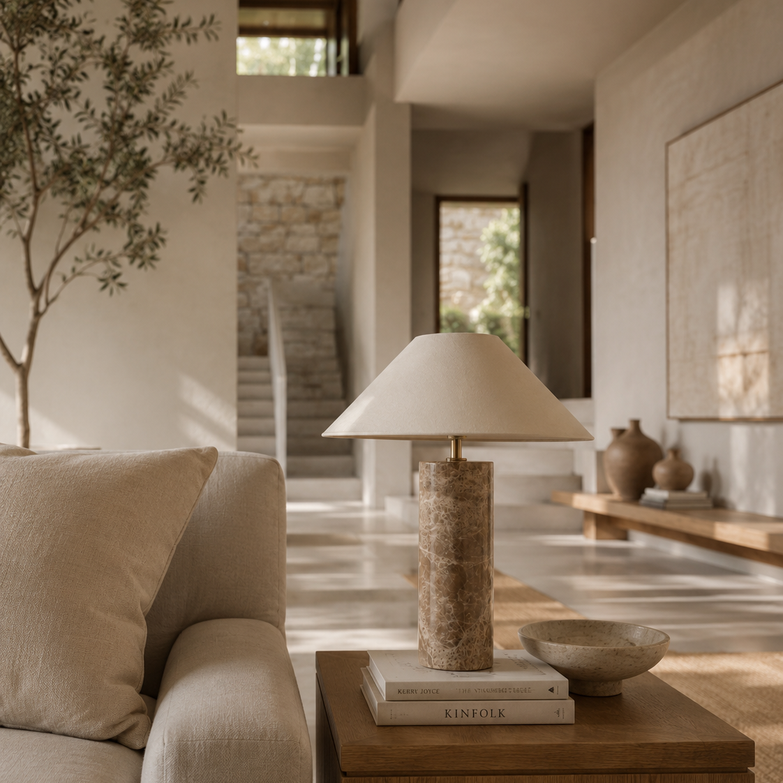Modern living room with a lamp on a wooden side table, neutral decor, and a plant.