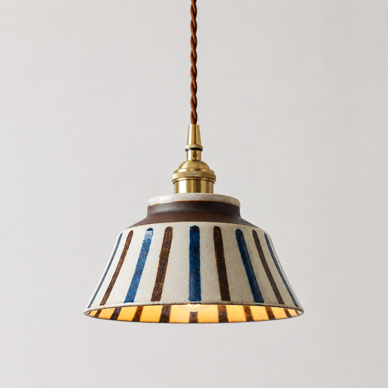 Pendant light with striped shade on a plain background
