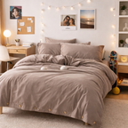Neatly made bed with beige bedding in a well-decorated bedroom.