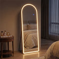 Futuristic standing mirror with glowing frame in a bedroom setting