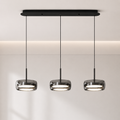 Modern pendant light fixture with three hanging lights on a neutral background