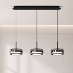 Modern pendant light fixture with three hanging lights on a neutral background