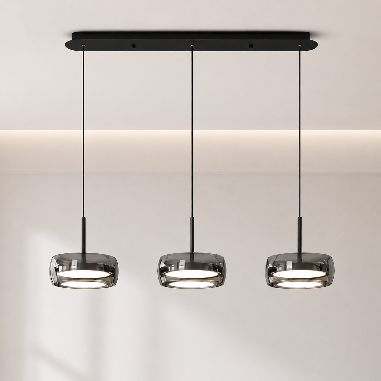 Modern pendant light fixture with three hanging lights on a neutral background