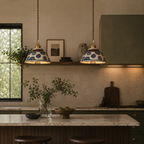 Kitchen interior with pendant lights, marble countertop, and decorative elements.
