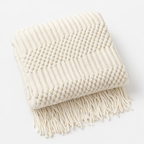 white blanket throw folded in a studio. 